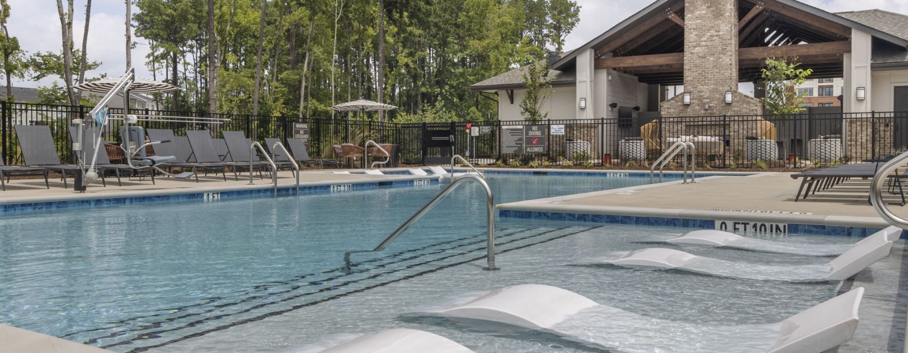 Pool with built in lounge chairs and clubhouse