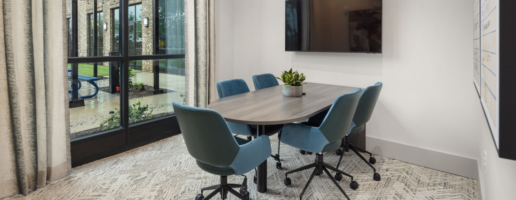 room with a table and chairs and tv on the wall